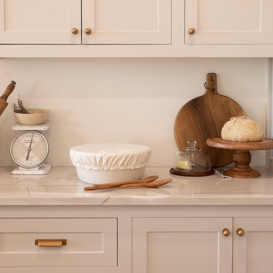 Kitchen counter with baking items including a scale, bowls, and wooden utensils.